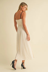 A woman wears an off-white sweetheart neckline contrast straps midi dress with fitted waist and thin black straps