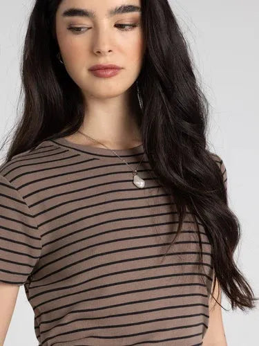 A woman wears a slim fitting thread and supply annie tee basic top with black and brown ribbed horizontal stripes