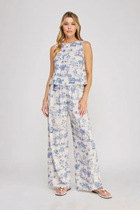 A woman wears off-white blue toile printed elastic tie waist wide leg pants with a sleeveless tiered top