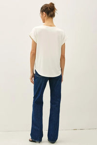 A woman wears a white bamboo round neck cap sleeve basic top with a relaxed fit and rounded neckline