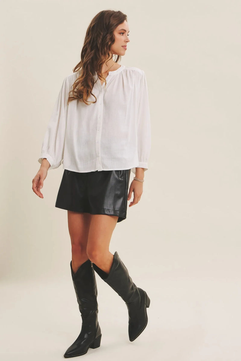 A woman wears a white espresso hour linen blend relaxed balloon blouse with puffed sleeves and button-down front