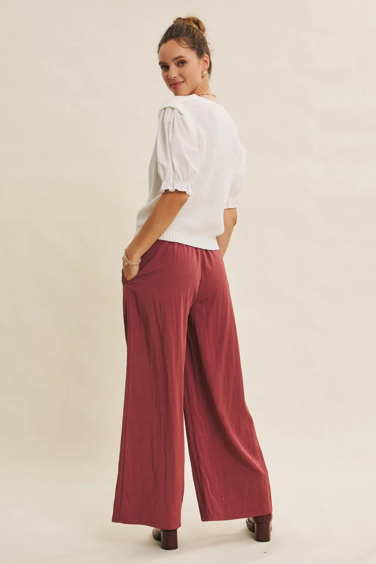 A woman wears white ribbed blouse and maroon step washed wide leg pants for a stylish casual look