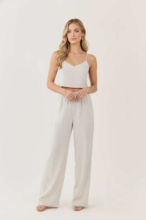 A woman wears white regular fit crosshatch pants with an elastic waistband paired with a matching crop top