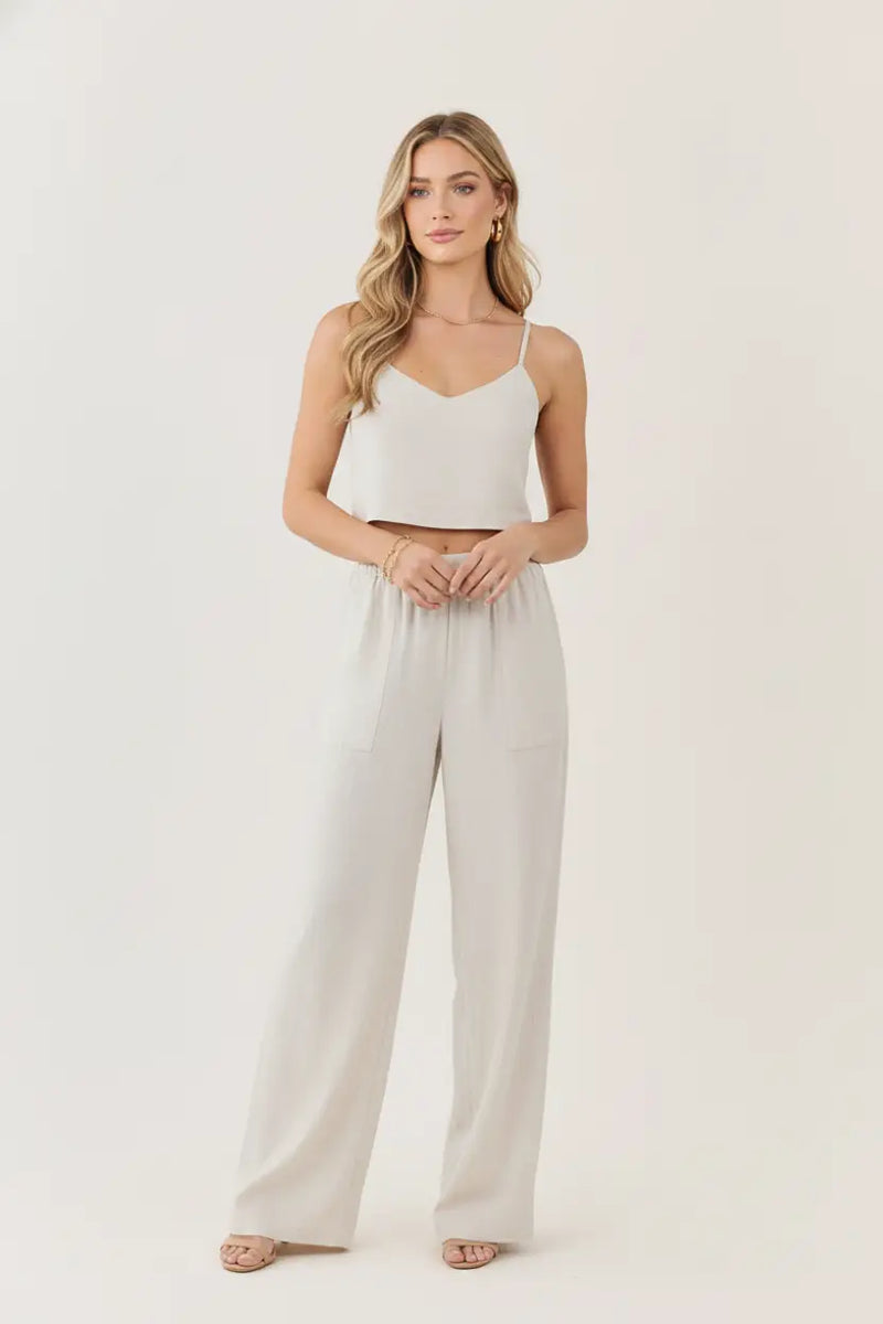 A woman wears white regular fit crosshatch pants with an elastic waistband paired with a matching crop top