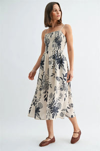 Off-white midi dress with navy blue floral pattern featuring thin spaghetti straps in a spaghetti straps smock style