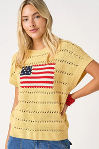 Yellow crocheted knit sweater top with a red white and blue american flag patch on the chest
