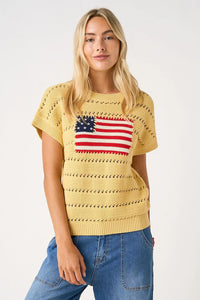 Yellow knitted sweater top featuring an american flag patch in red white and blue on the chest