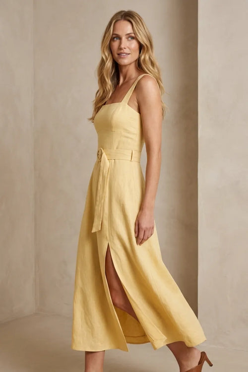 A flowing yellow linen midi dress with a square neck buckle, thin straps, and self-tie belt at the waist
