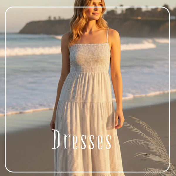 A flowing, off-white tiered maxi dress with delicate spaghetti straps and a textured fabric.