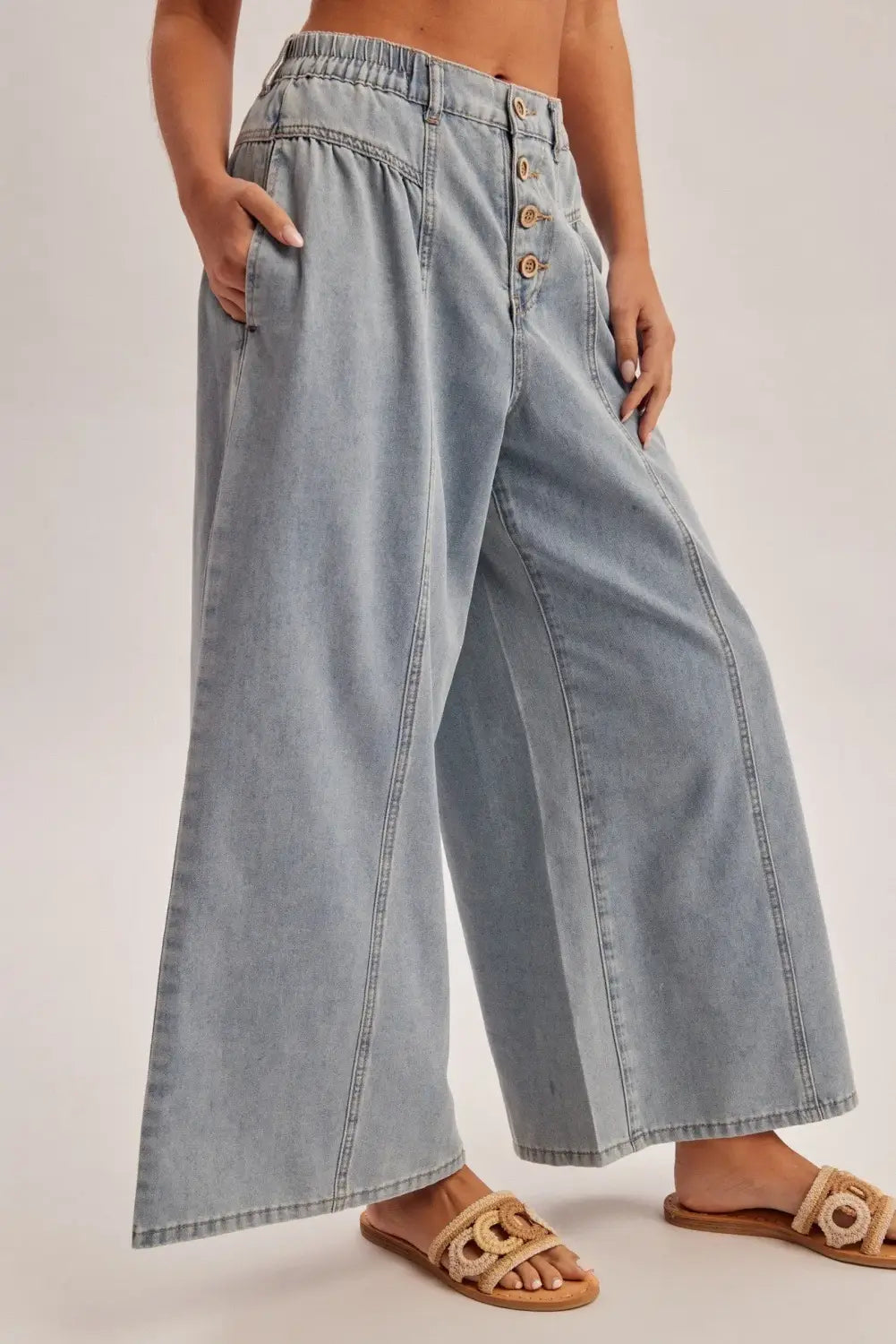 light-wash denim wide-leg pants featuring a high rise elastic waist and front button closure perfect for a relaxed yet stylish look