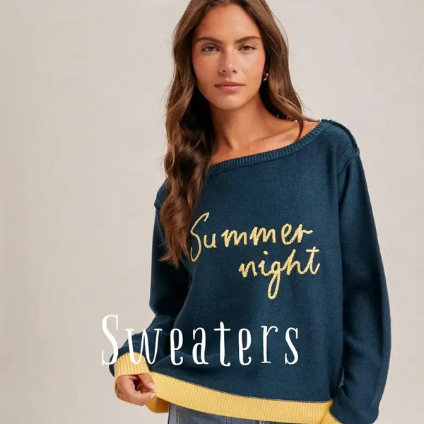 A navy blue knit sweater with gold embroidered text reading ’summer night’ and contrasting yellow ribbed cuffs.