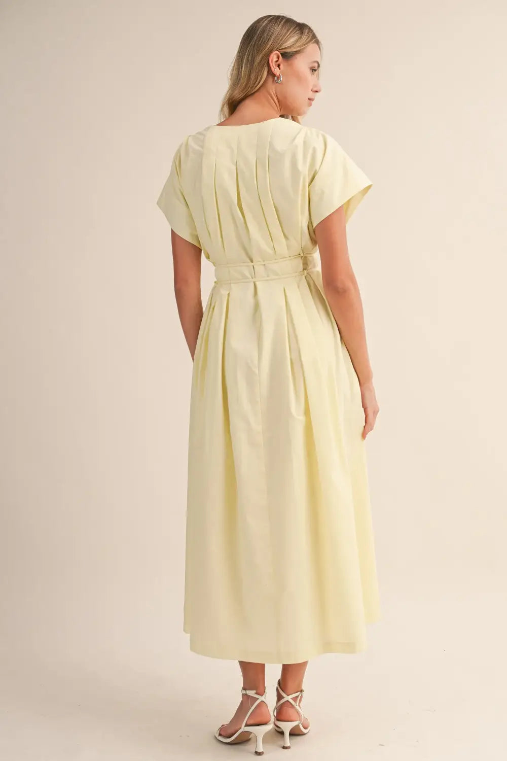 a flowing pale yellow poplin belted maxi dress with v-neckline short draped sleeves and cinched waist belt