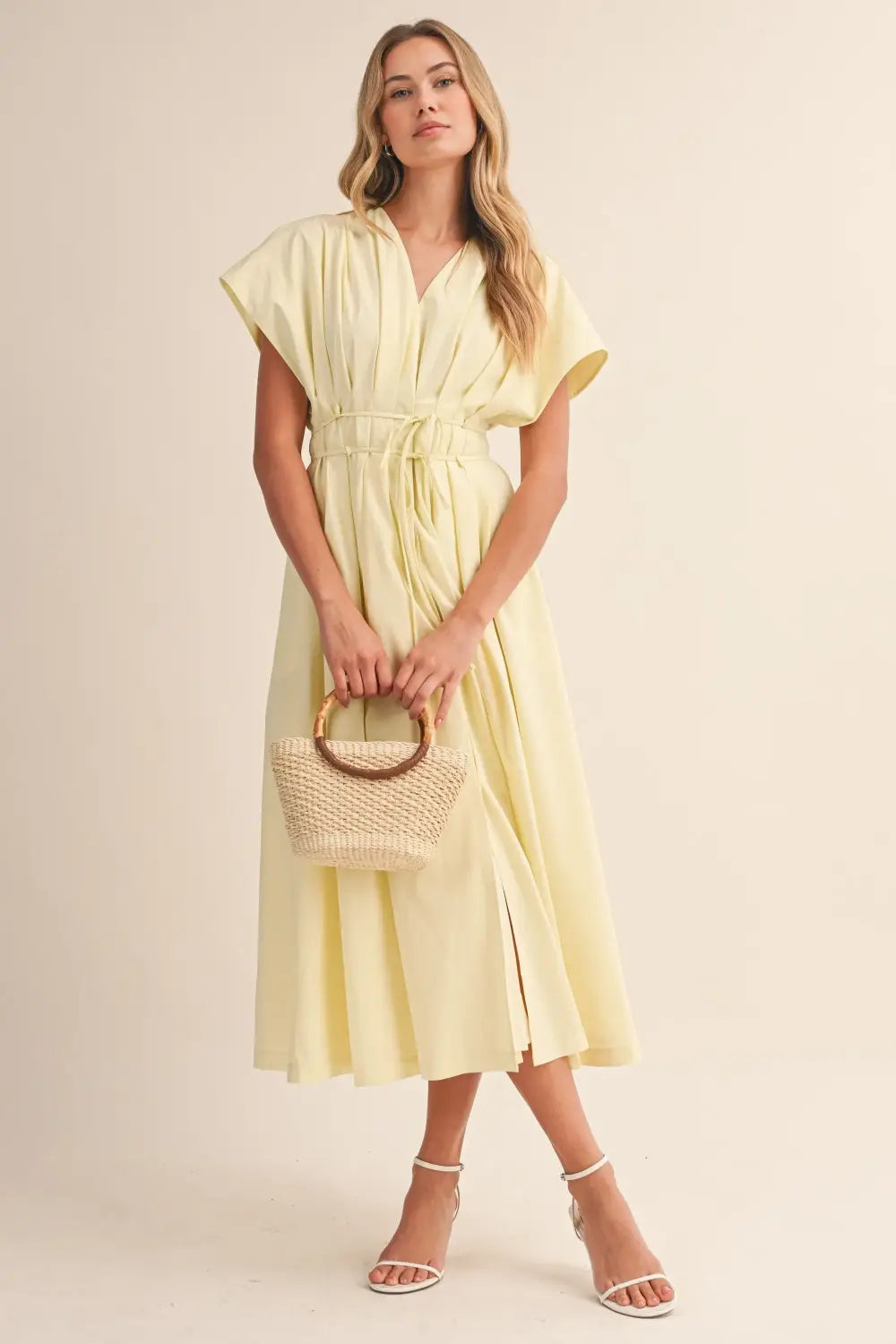 a flowing pale yellow poplin belted maxi dress with v-neckline short draped sleeves and cinched waist belt
