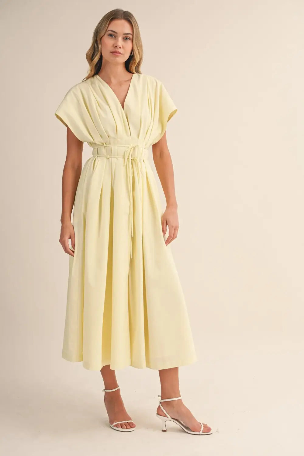 a flowing pale yellow poplin belted maxi dress with v-neckline short draped sleeves and cinched waist belt