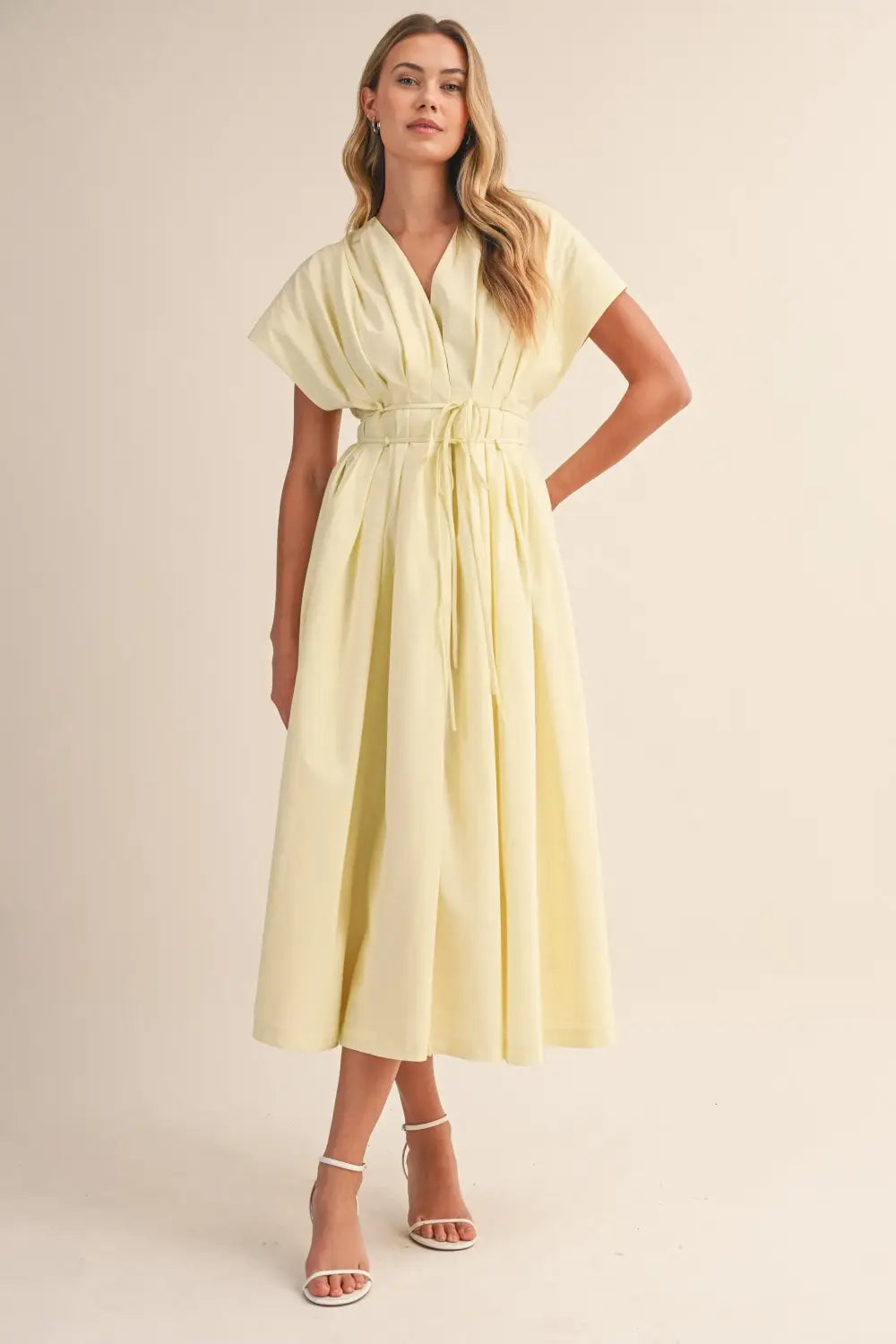 a flowing pale yellow poplin belted maxi dress with v-neckline short draped sleeves and cinched waist belt