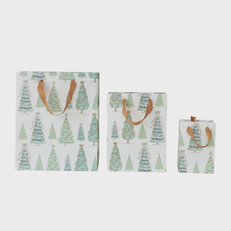 Three handmade gift bags with Christmas tree pattern and brown handles for festive gifting