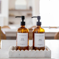 Amber glass hand soap bottle with black pump and minimalist white label