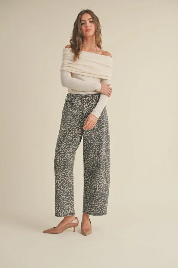 Leopard print barrel pants styled with an off-shoulder white sweater and nude heels