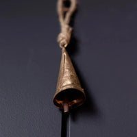 Tapered brass bell ornament with antique gold finish, rope hanger, and metal clapper