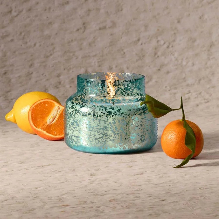 Aqua blue textured mercury glass candle with lit wick from Capri Blue Blue Signature Collection