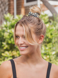 Arafed woman in a black top wearing a boho bandeau headband with floral design