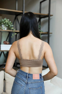 Back view of a woman showcasing the seamless lace strap bralette paired with jeans