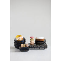 Assorted black ceramic plates and bowls with desserts on MINI STONEWARE DISH