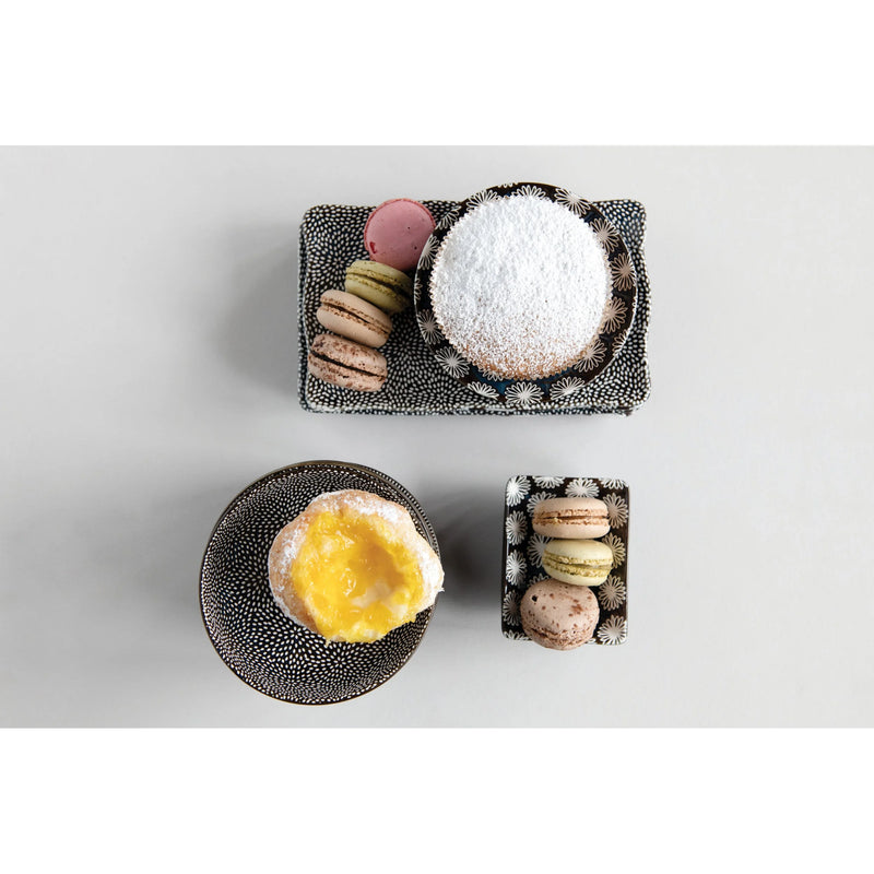 Assortment of desserts on decorative plates in a stylish mini stoneware dish