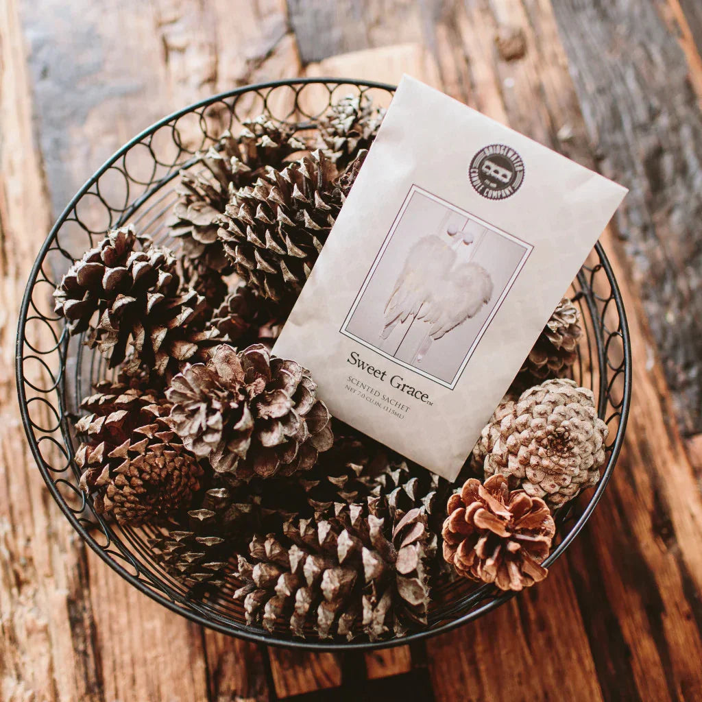 Bag of Sweet Grace scented sachets with coffee and pine cones on wooden table