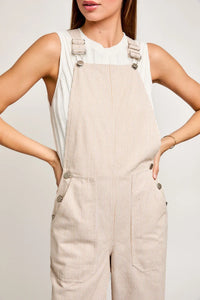 Beige corduroy overalls with adjustable straps in a flowy wide leg design