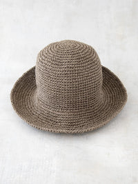 Beige KIARA Bucket Hat made from natural raffia with a wide brim and rounded crown