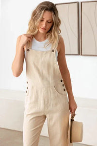 Beige linen overall jumpsuit over a white tank, perfect for a boho free spirit style