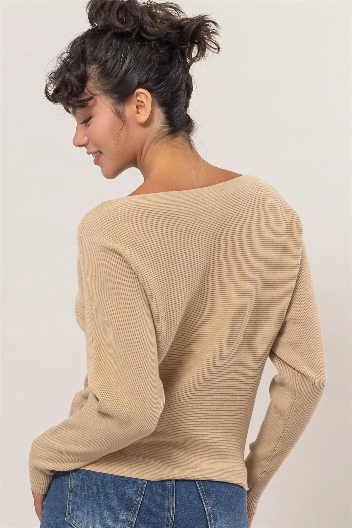 Beige ribbed long sleeve sweater with a boat neckline displayed from the back