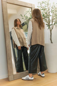 Beige sleeveless vest with wide straight leg leather pants and white sneakers