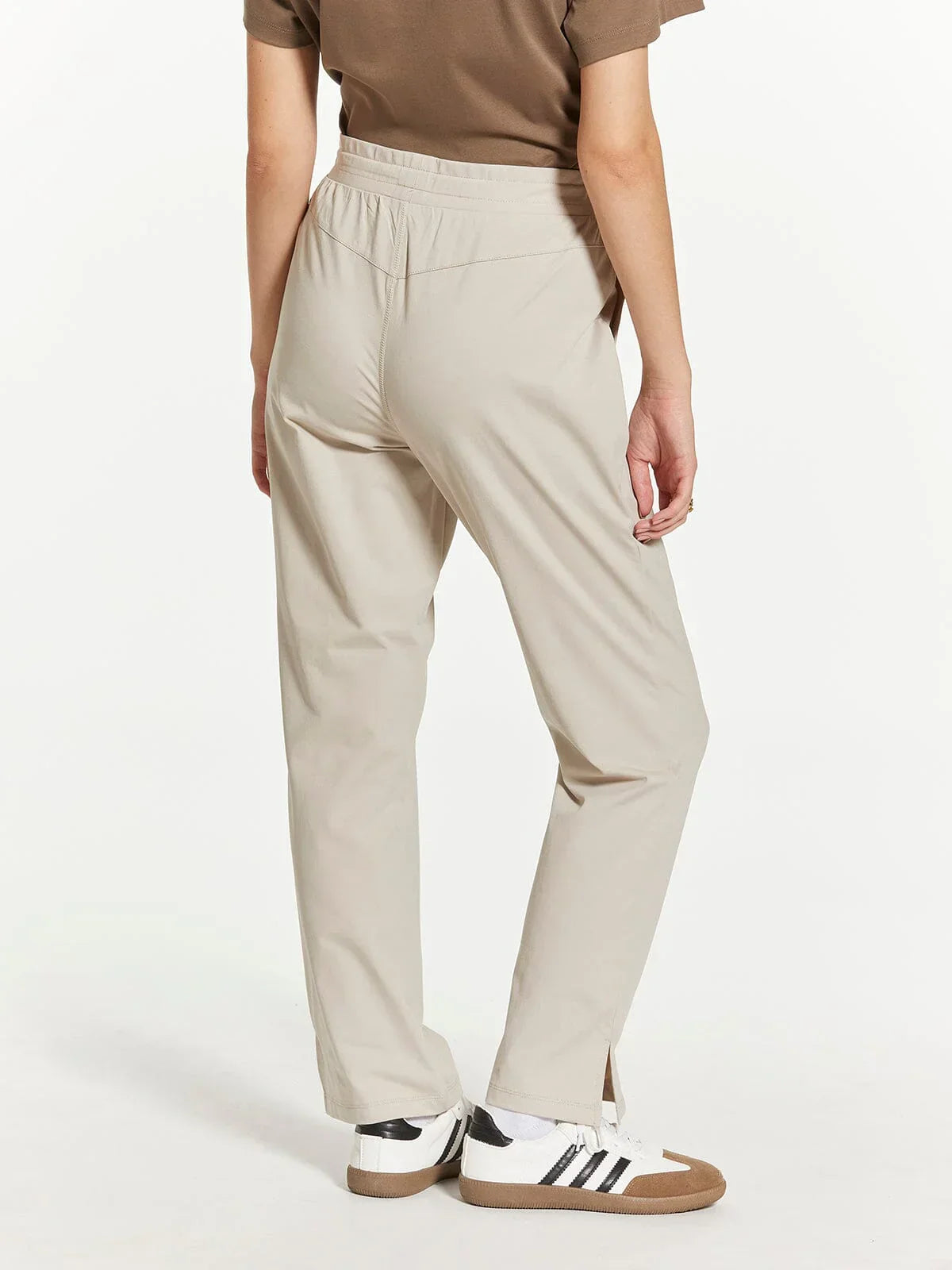Beige straight-leg Supply Paige pants with elastic waistband and white Adidas sneakers