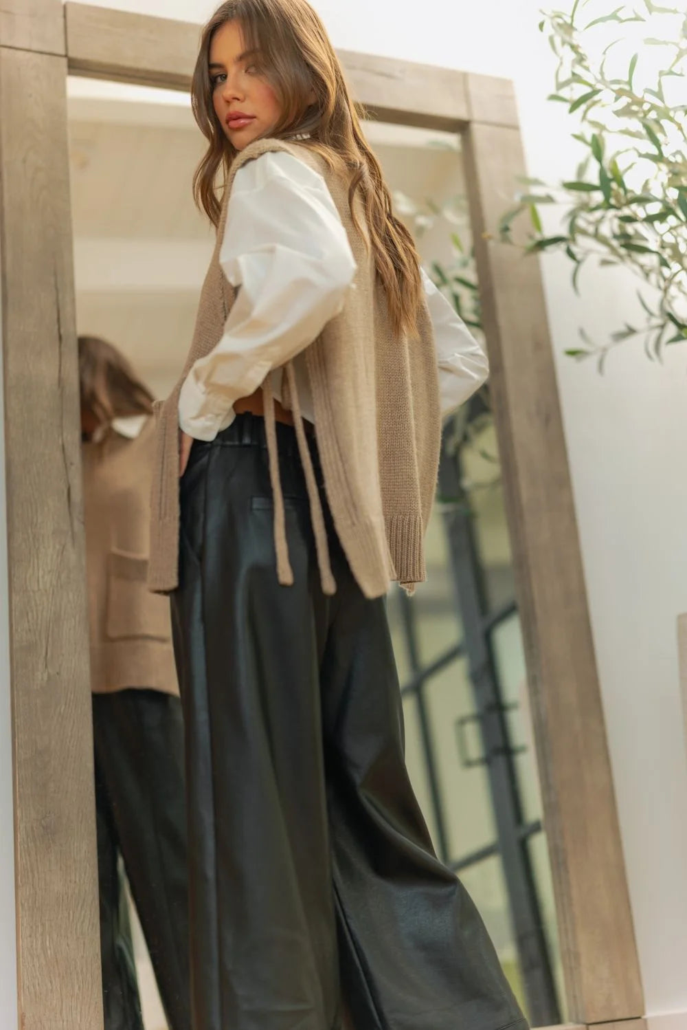 Beige and white striped cardigan with wide straight leg leather pants