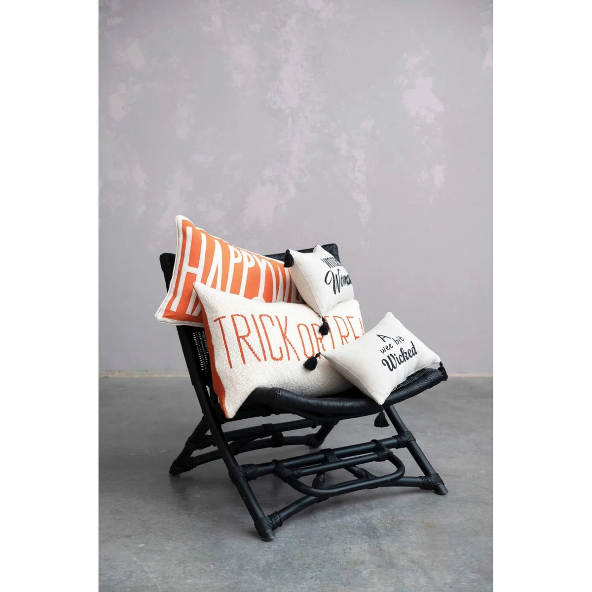 Black folding chair adorned with Halloween-themed pillows from Shop Daisy, perfect for fall trick