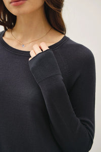 Black raglan long sleeve sweater with thumbholes and delicate necklace, perfect for women’s boho chic clothing