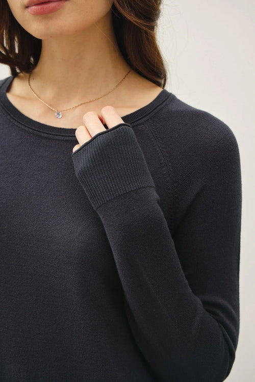 Black raglan long sleeve sweater with thumbholes and delicate necklace, perfect for women’s boho chic clothing