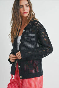 Open stitch crochet black mesh button-up cardigan over white top and red plaid pants