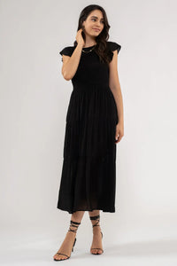 Black smocked tiered midi dress with strappy heels for elegant occasion wear