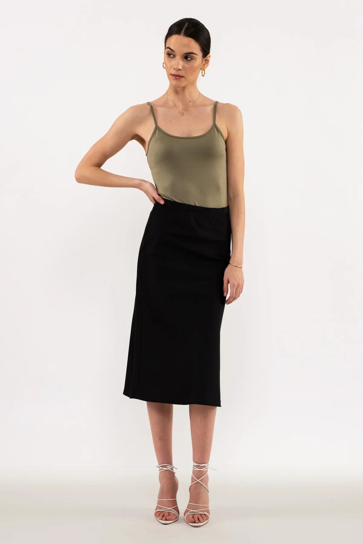 Black midi pencil skirt with olive green spaghetti strap tank top and strappy sandals