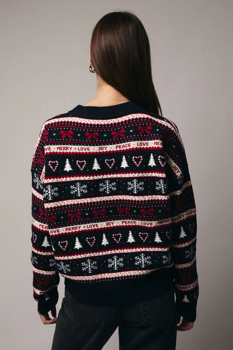Round neck graphic Christmas sweater in black and pink with snowflakes, trees, hearts, and peace love text