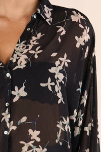 Black sheer long sleeve button-up blouse with white floral pattern and collar