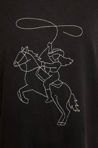Black T-shirt with white embroidered cowgirl on horseback showcasing western line stitch design