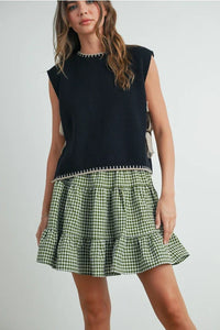 Mock neck sleeveless sweater in black with green gingham ruffle hem