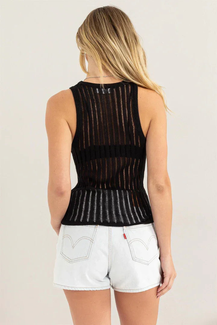 Black sleeveless open knit sweater tank top styled with white shorts for a boho look