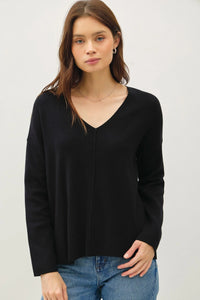 Black V-neck sweater with center seam, long sleeves, and a relaxed boho style