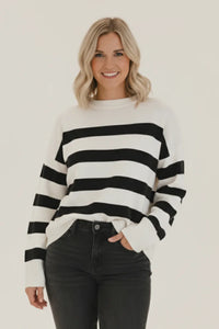 Black and white striped crew neck sweater with ribbed cuffs