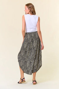 Black and white polka dot midi skirt with curved hemline, perfect for women’s boho chic clothing